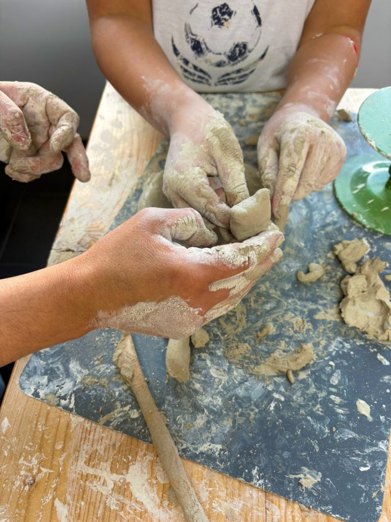 Kinder und Eltern modellieren gemeinsam Ton im Töpfer-Familienkurs in Köln der Kölner Kinderwerkstatt