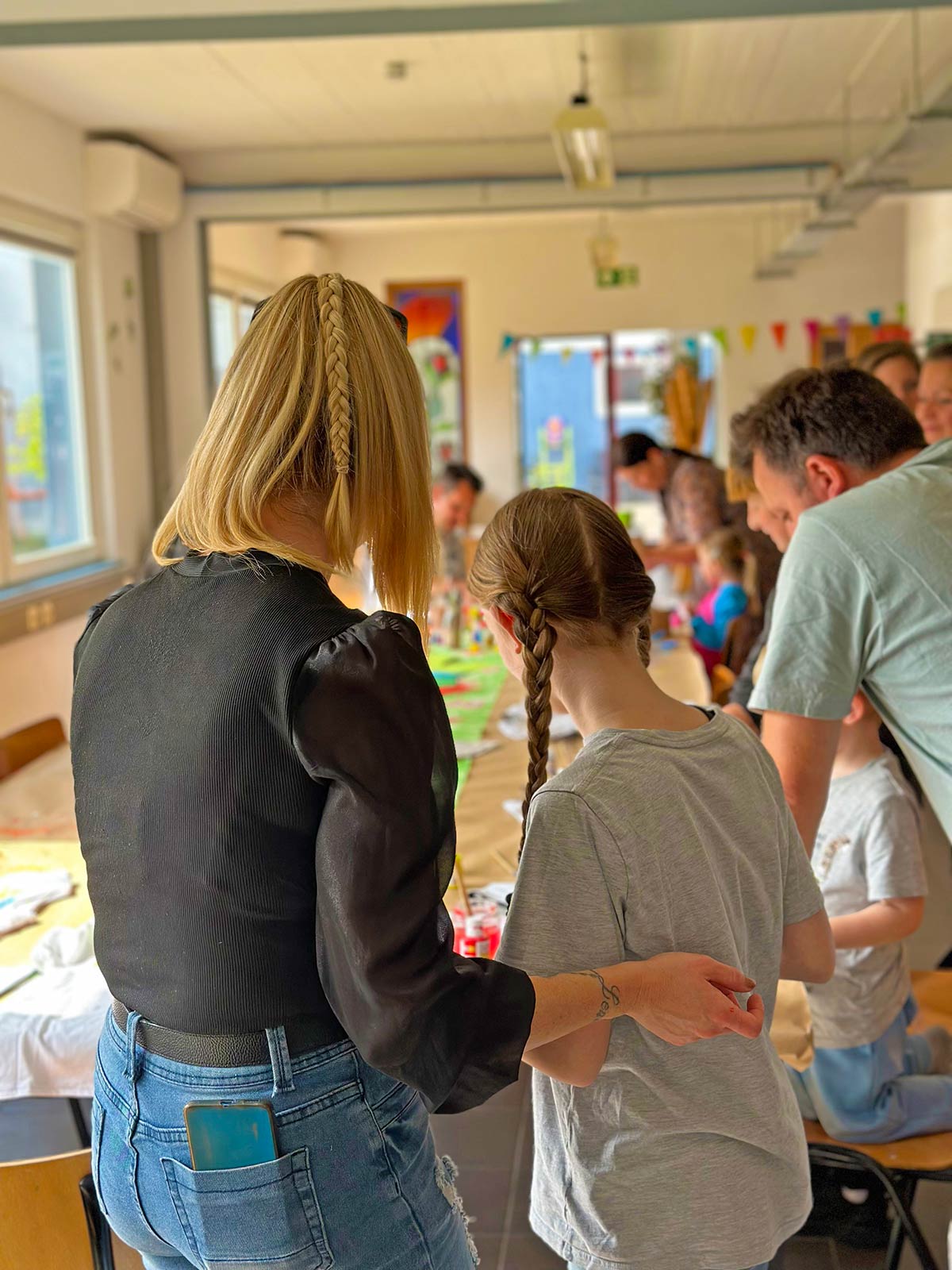 Kind wird im Sommerferienkurs der Kölner Kinderwerkstatt in Köln liebevoll beim kreativen Arbeiten begleitet.