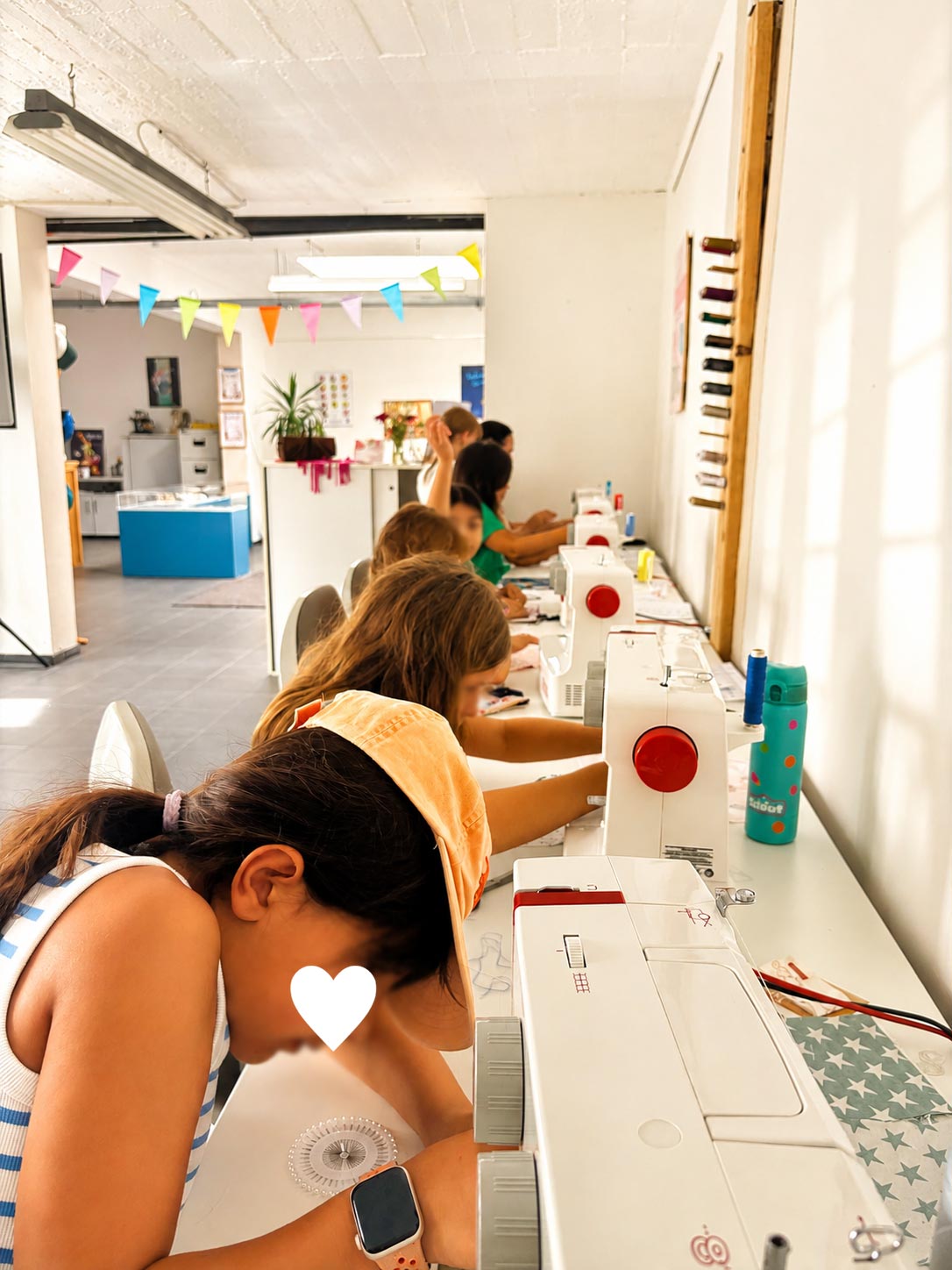 Kinder arbeiten an Nähmaschinen im Kurs Nähen & Mode der Kölner Kinderwerkstatt in Köln